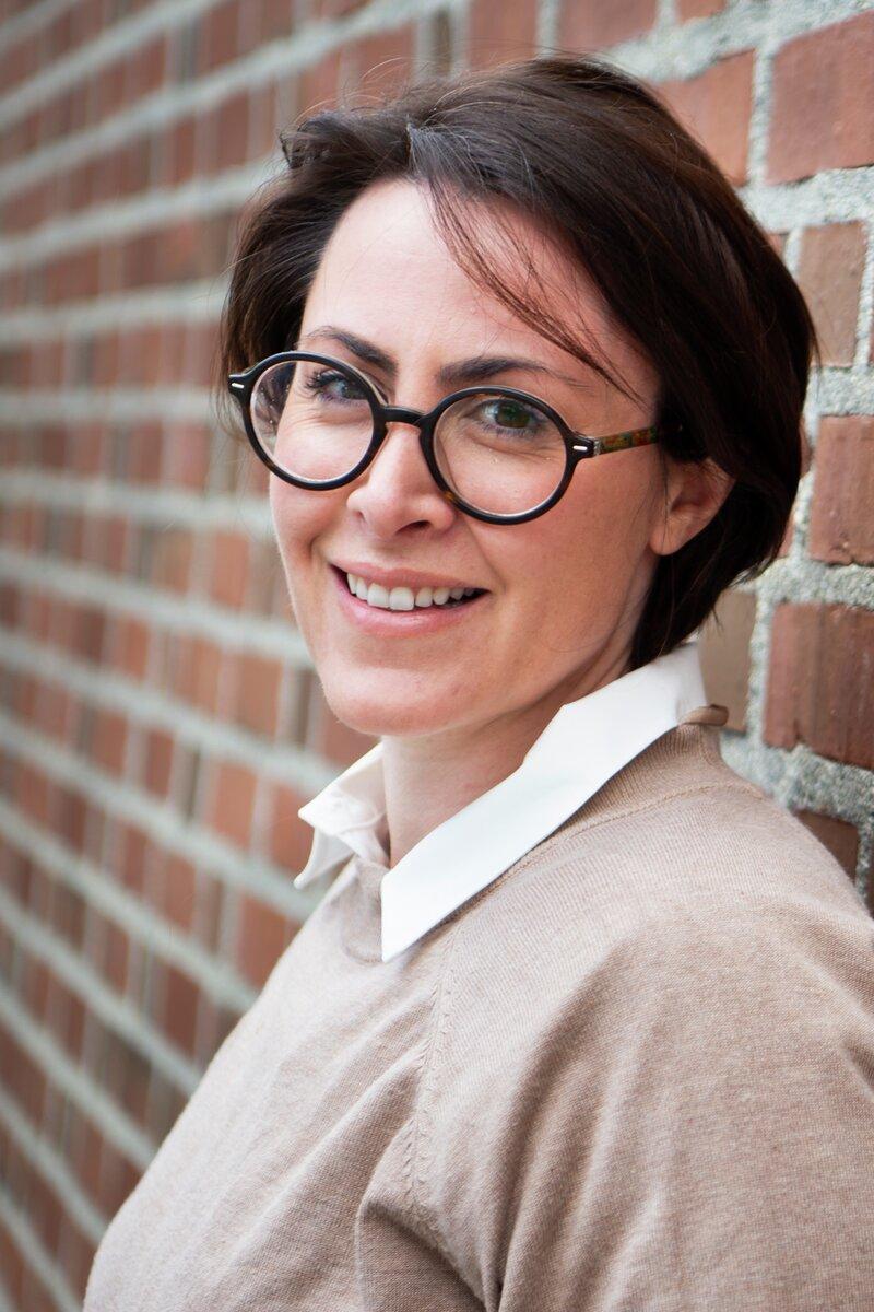 melina duarte foto stig brøndbo uit.jpg portertt av ev kvinne som lener seg mot en murvegg